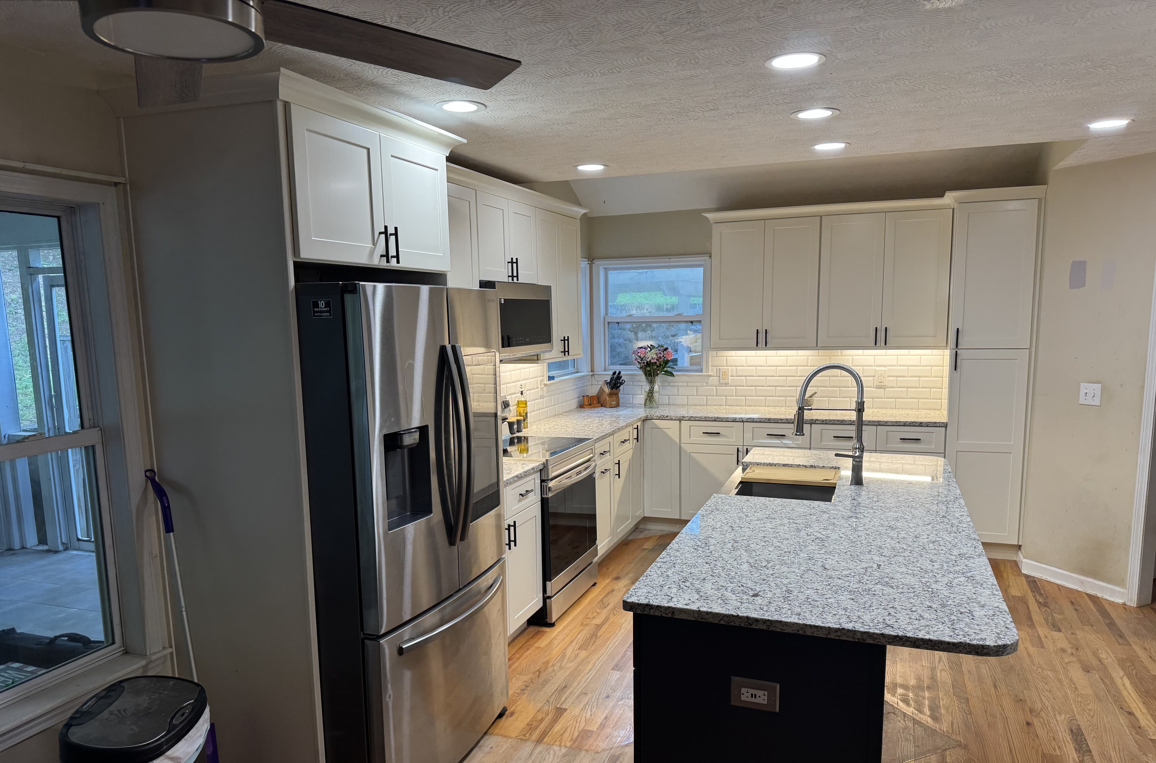 White shaker cabinets, subway tile backsplash, and open shelving — S&T Construction remodel