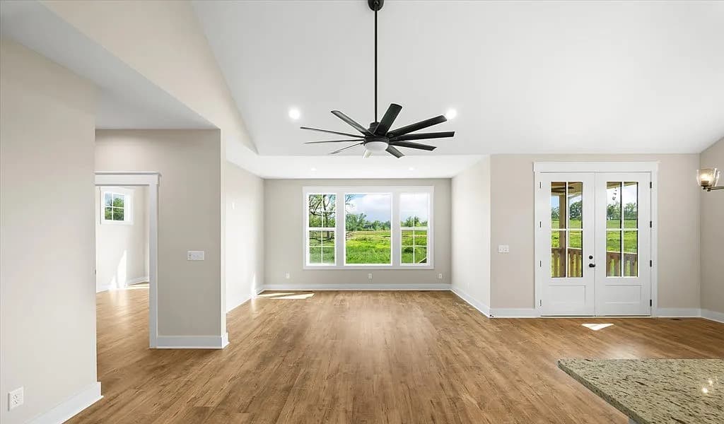 Open great room with hardwood floors and French doors — S&T Construction