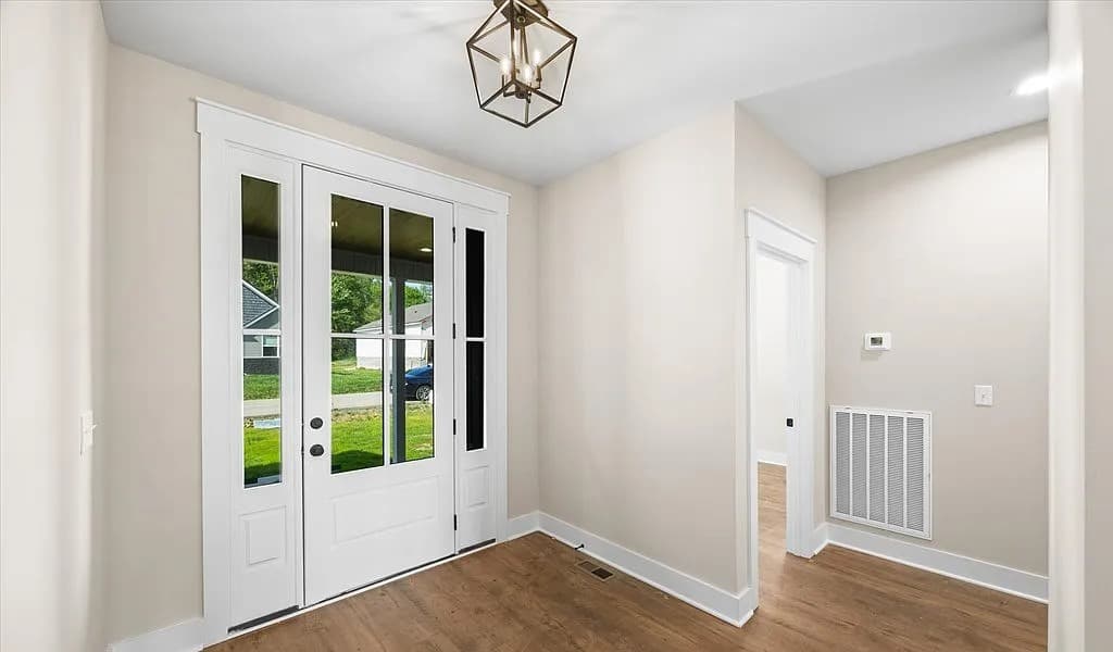 Bright entryway with glass front door and lantern chandelier — S&T Construction