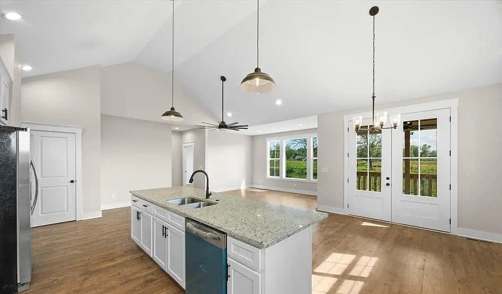 Living room with hardwood floors and natural light — The Kaley by S&T Construction