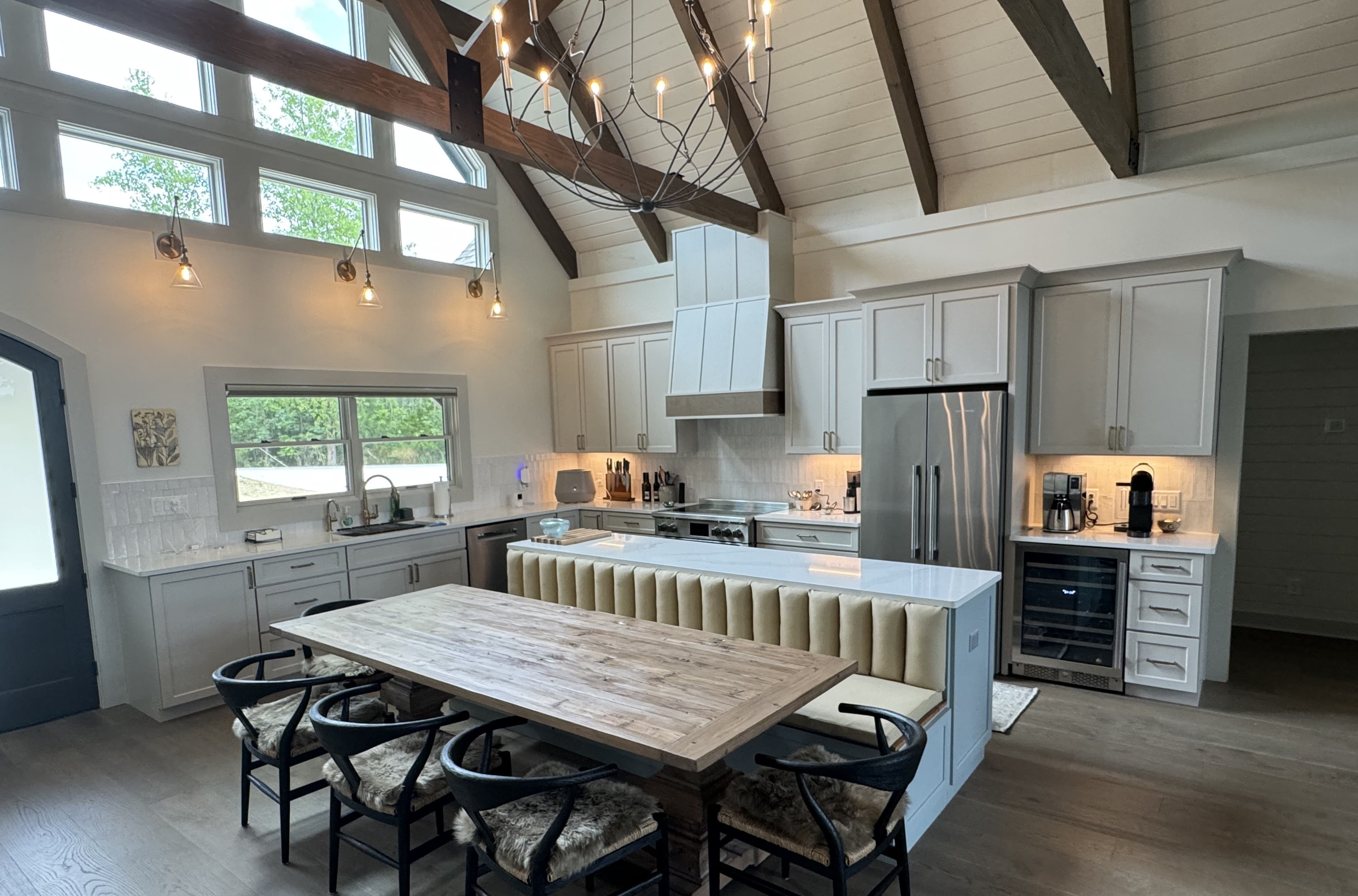 Custom home kitchen with a vaulted shiplap ceiling, exposed beams, and a chandelier, built by S&T Construction in Cookeville, TN